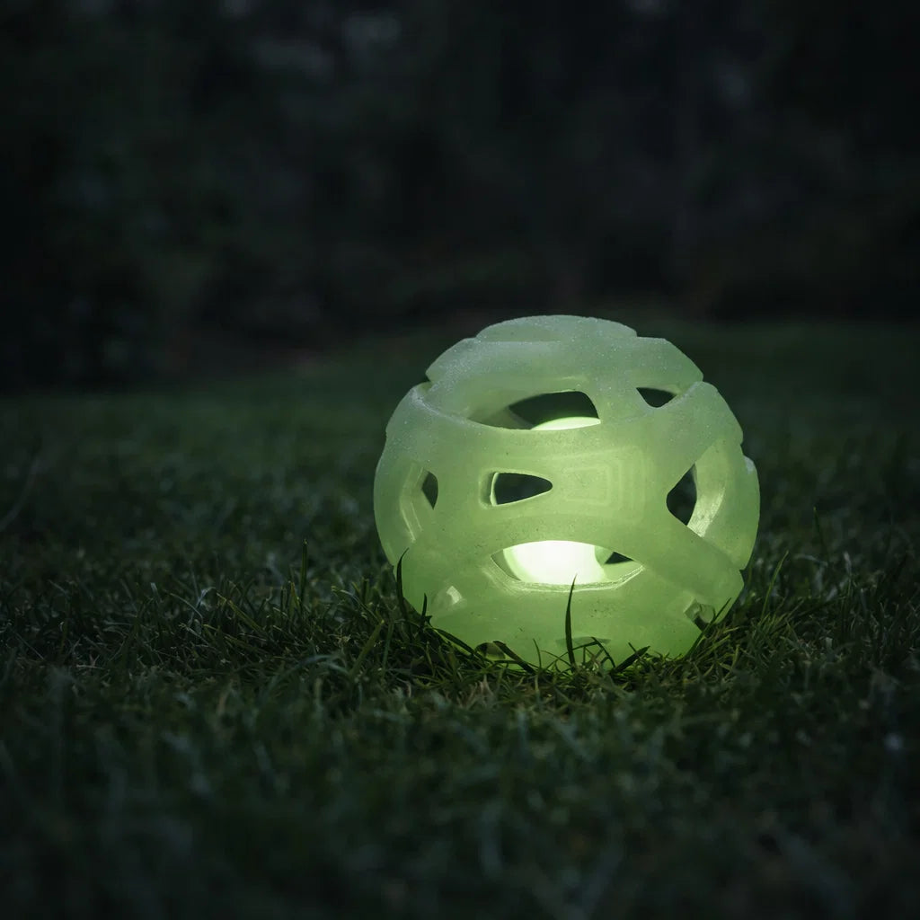 Glow in the dark breathable fetch ball glowing on grass at night