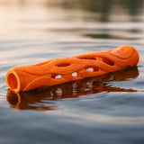 Orange breathable dog fetch stick floating on calm water surface