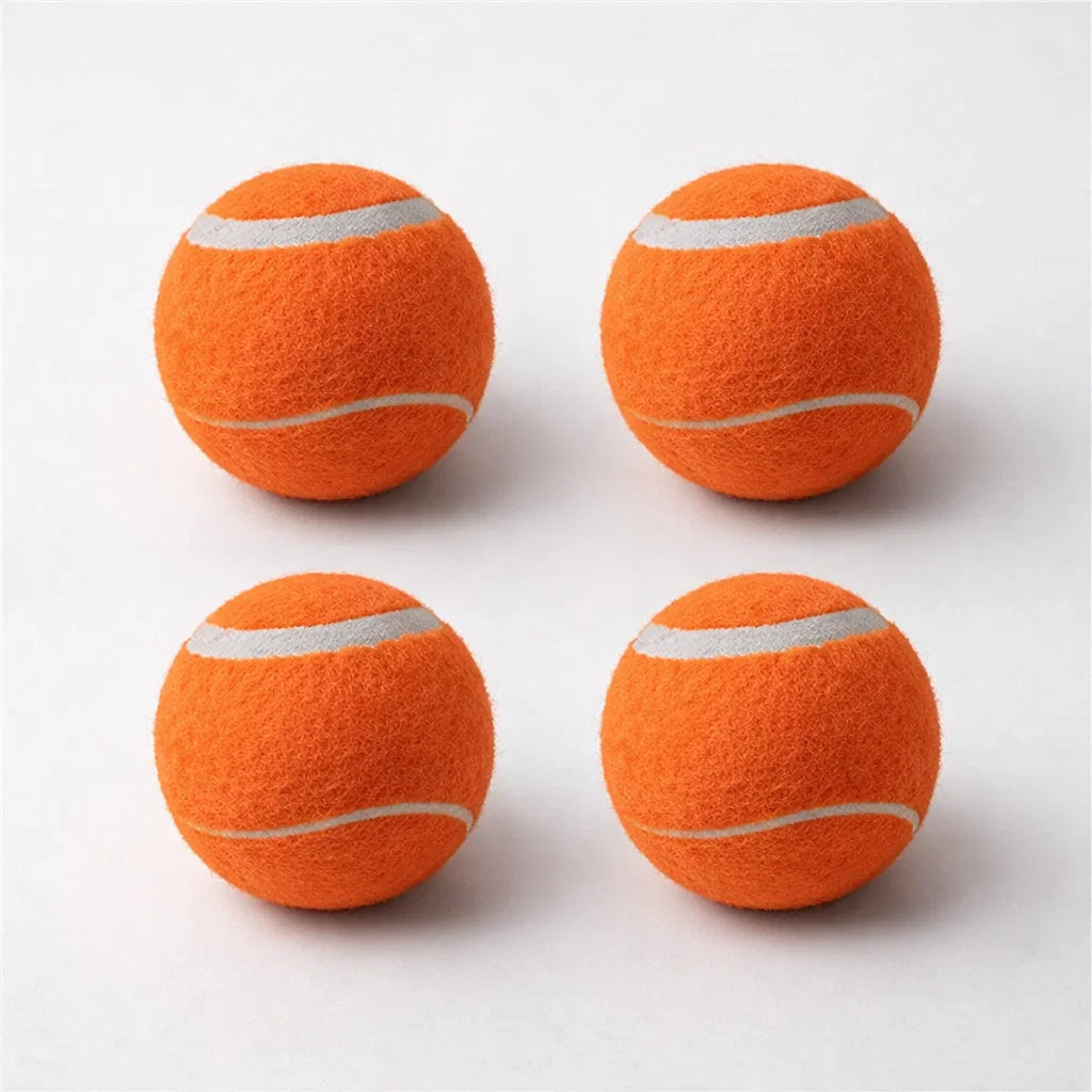 Four orange Chuckit tennis balls arranged on a clean studio background