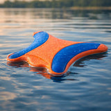 Chuckit Ultra Flying Squirrel dog toy floating on calm lake water surface