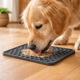 Golden Retriever licking food from grey silicone lick mat